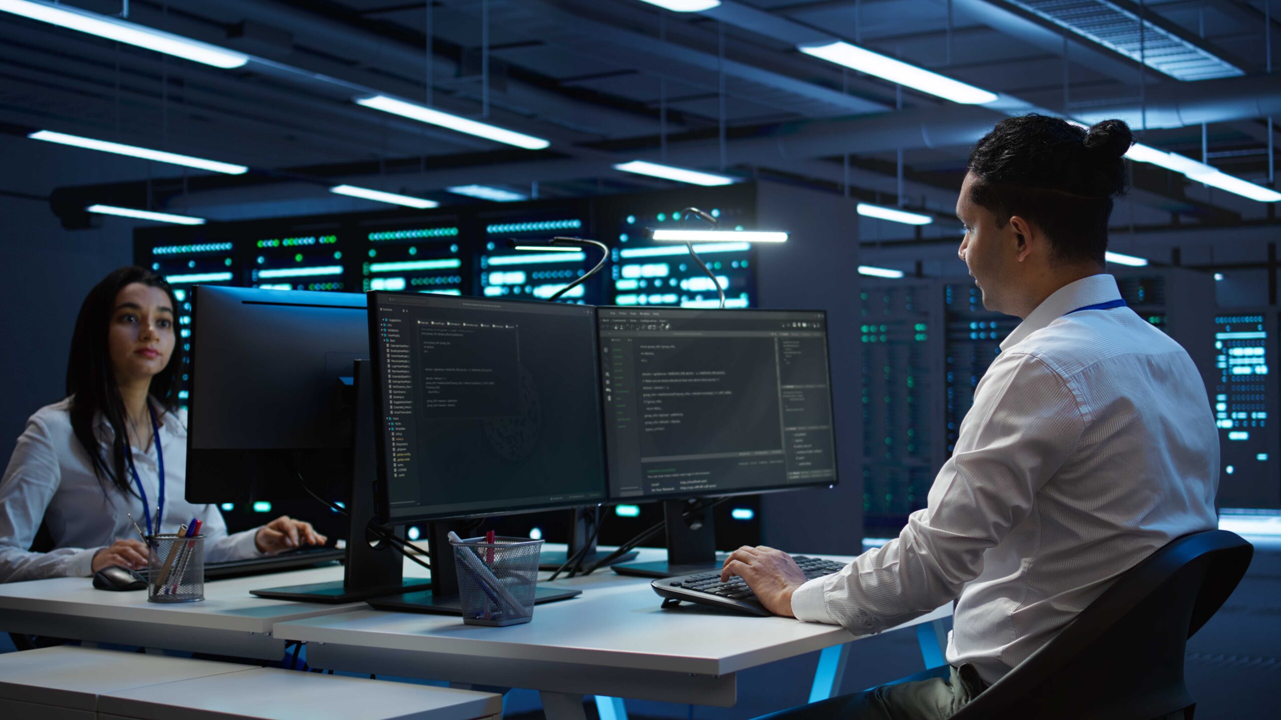 Engineers in high tech data center establishment installing software on computer, troubleshooting issues. Team of IT specialists in server room establishing performance benchmarks